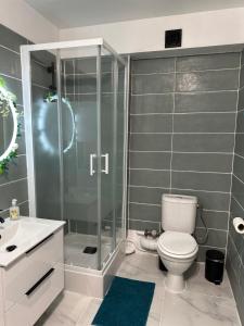 a bathroom with a shower and a toilet and a sink at Orphea - Charming Studio Villeparisis - Proche gare / CDG / Parc des expositions in Villeparisis