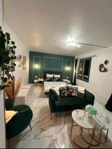 a living room with a bed and a couch at Orphea - Charming Studio Villeparisis - Proche gare / CDG / Parc des expositions in Villeparisis