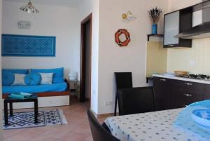 uma cozinha e uma sala de estar com um sofá azul em CASA LU DO' em Agrustos
