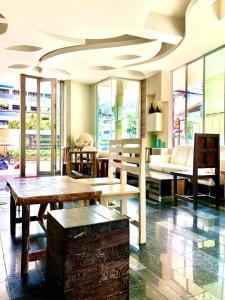 un soggiorno con tavoli e divano di O-Bay Design Hotel Prachuap a Prachuap Khiri Khan