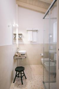 a bathroom with a glass shower and a stool at Locanda Golf Musella in San Martino Buon Albergo