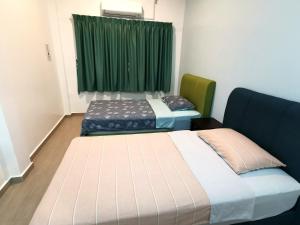 two beds in a room with a green curtain at Amuse Homestay at Kuala Kubu Bharu in Kuala Kubu Baharu