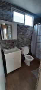 a bathroom with a toilet and a sink and a window at Quinta barrio cerrado pileta tranquilidad naturaleza in Francisco Álvarez