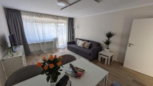 - un salon avec un canapé et une table fleurie dans l'établissement Schöne Wohnung Kerpen, à Kerpen