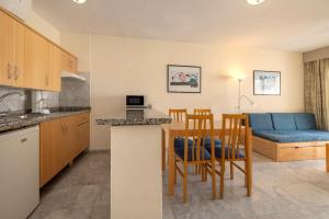 a kitchen and a living room with a table and chairs at whala!tenerife - Formerly Marola Portosin in Playa de las Americas