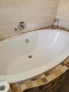 a white bath tub sitting in a bathroom at Sagewood Manor in Midrand
