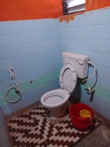 un bagno sporco con servizi igienici e secchio di Goroomgo J K Inn Puri Sea View Room a Puri