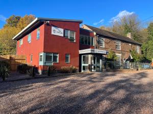 a large red building with a driveway in front of it at The Poplars - Cosy Modern Flat with Great Networking in Telford