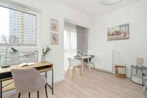 una oficina con escritorio, sillas y mesa en Minimalist Studios Wojciechowskiego with Parking in Poznań by Renters en Poznan