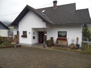 una casa blanca con un banco delante en Ferienwohnung Hof 22, en Hilchenbach