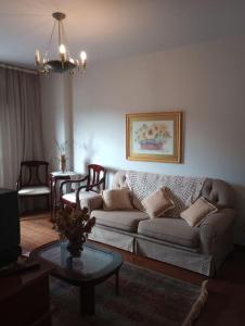 a living room with a couch and a table at Apartamento in São Lourenço