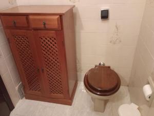a bathroom with a toilet and a wooden cabinet at Apartamento no Centro de São Lourenço in São Lourenço