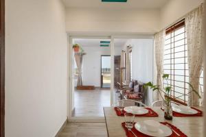 a dining room with a table and chairs and a living room at Surfside Haven By JadeCaps 1BHK By Udupi Beach in Kōtatattu