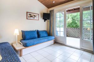 ein Wohnzimmer mit einer Couch und einem Fenster in der Unterkunft Village Moliets - maeva Home - 2 Pièces 7 Personnes Confort MAE-2247 in Moliets-et-Maa