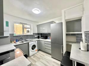 Fabulous 3 bedroom flat sleeps 6 في لندن: مطبخ مع ثلاجة وغسالة ومجفف