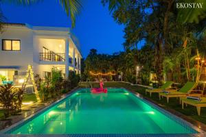 - une piscine en face d'une maison la nuit dans l'établissement Ekostay Luxe - CASA SIA - Ideal for Weddings - Poker Table, à Lonavala