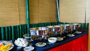 a row of drums on a table with plates of food at Vayalada View Point Resort in Kozhikode
