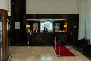 zwei Frauen, die hinter einem Tresen in einer Lobby stehen in der Unterkunft Holiday Inn Aktau, an IHG Hotel in Aqtau