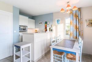 eine Küche mit einem kleinen Tisch und Stühlen im Zimmer in der Unterkunft Les Maisons de Belle Dune - maeva Home - Maison 3 Pièces 6 Personnes Confort MAE-2273 in Fort-Mahon-Plage