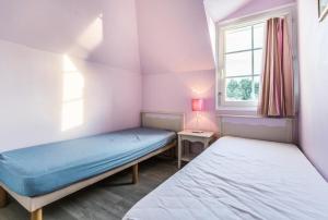 zwei Betten in einem kleinen Zimmer mit Fenster in der Unterkunft Les Maisons de Belle Dune - maeva Home - Maison 3 Pièces 6 Personnes Confort MAE-2273 in Fort-Mahon-Plage