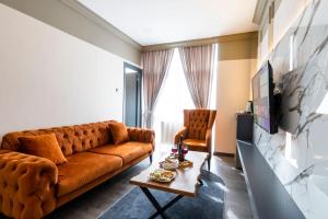 Lara Apartments في إسطنبول: غرفة معيشة مع أريكة بنية وطاولة
