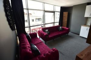 a living room with a red couch and a large window at Lara Apartments in Istanbul