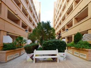a white bench sitting in the middle of a building at Apartamentos Costamar 3000 in Torre de la Sal