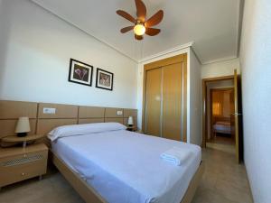 a bedroom with a bed and a ceiling fan at Apartamentos Costamar 3000 in Torre de la Sal +31 photos