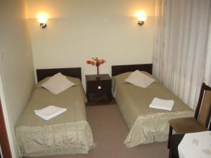 2 camas en una habitación de hotel con toallas en Zajazd Michałowo, en Michałowo