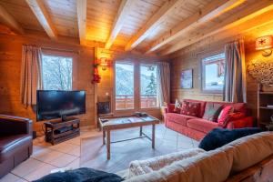 een woonkamer met een bank en een tv bij Cosymontagne - Le Chalet - 3Ch - 8 pers- Terrasse Sud, magnifique vue in La Clusaz