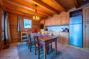 kuchnia ze stołem, krzesłami i lodówką w obiekcie Cosymontagne - Le Chalet - 3Ch - 8 pers- Terrasse Sud, magnifique vue w mieście Clusaz