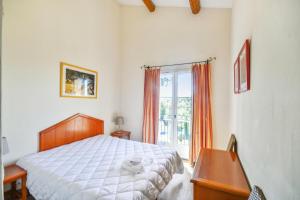 a bedroom with a bed and a desk and a window at Les Maisons de Pont Royal en Provence - maeva Home - Maison climatisée pour 8 Personnes avec jardin privatif et terrasse MAE-2283 in Mallemort +29 photos