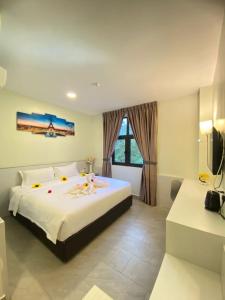 um quarto com uma cama grande e uma janela em Well Hotel By Maco at Legoland em Gelang Patah
