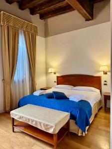 a bedroom with a large bed with a blue blanket at Locanda del Ghetto in Venice