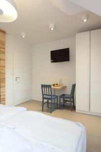 a bedroom with two chairs and a table with a tv on the wall at Dom Wakacyjny Solano in Ustka