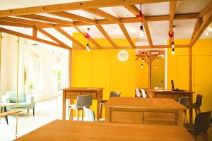 une salle à manger avec des murs jaunes et des tables en bois dans l'établissement Résidence Port Bourgenay - maeva Home - Studio 4 Personnes Sélection 20, à Talmont-Saint-Hilaire