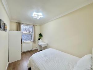 ein weißes Schlafzimmer mit einem Bett und einem Fenster in der Unterkunft The Euston Guest House-64 in London