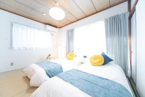 2 camas en un dormitorio con ventana grande en Suzuka Smile Room, en Suizawa