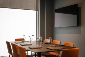 einen Konferenzraum mit einem Tisch mit Stühlen und einem Bildschirm in der Unterkunft Luxury Apartment Cherrywood Dublin 18 in Dublin