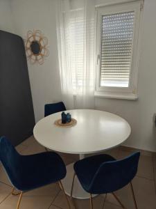 una mesa y sillas blancas en una habitación con ventana en Maison 5 chambres proche Basel Germany, en Saint-Louis