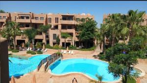 ein Resort mit einem großen Pool vor einem Gebäude in der Unterkunft Villa Agdal in Marrakesch