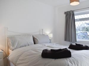a white bed with two black towels on it at Crosslands in Penrith
