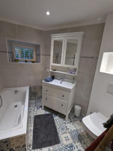 a bathroom with a sink and a tub and a toilet and a sink at La Brigandine in Bormes-les-Mimosas