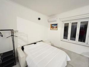 a white hospital room with a bed and windows at Casa MEC Imperia in Imperia