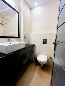 uma casa de banho com um lavatório branco e um WC. em Hotel JPM Stay - East Of Kailash em Nova Deli
