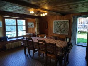a dining room with a table and chairs and windows at Chalet La Gayolle - Chalets pour 12 Personnes 96 in Saint-Gervais-les-Bains