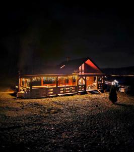 a house lit up at night with christmas lights at DOMEK KARMELOWY - Azyl Na Szwedach in Ruszelczyce