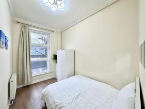 a bedroom with a white bed and a window at The Euston Guest House-64 in London