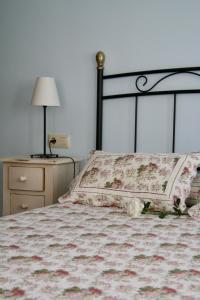 a bed with a pillow and a lamp on a table at Apartamentos Rurales La Bardenilla in Panes