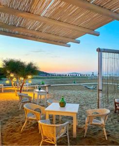 un patio con tavoli e sedie sulla spiaggia di Hotel Gargano a Vieste